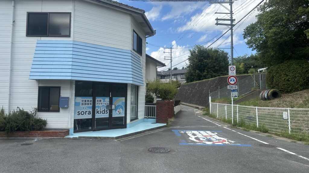 水色の建物「sora kids」さんの角と細い道の写真