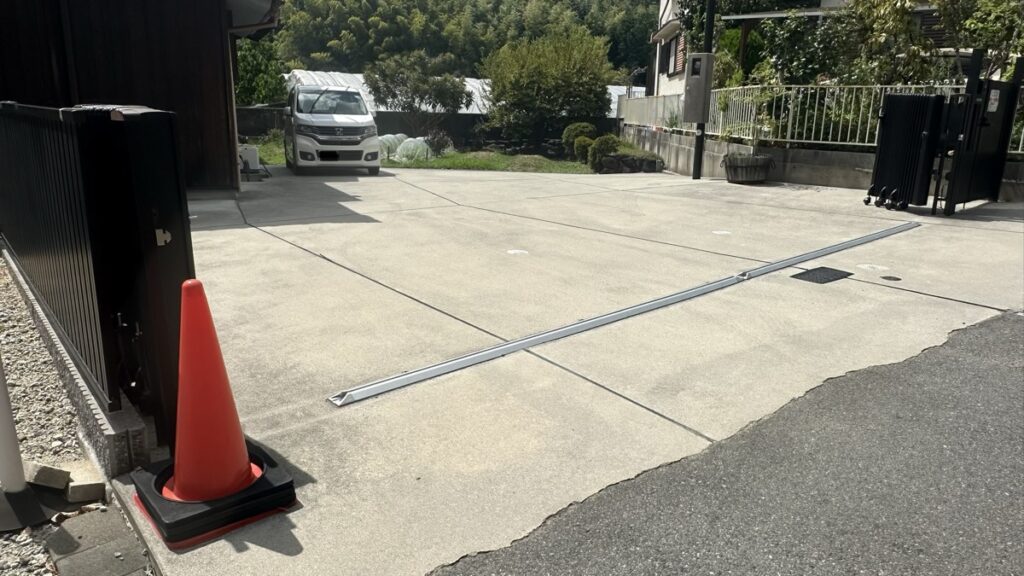 黒い門とコーンが目印の駐車スペースの写真